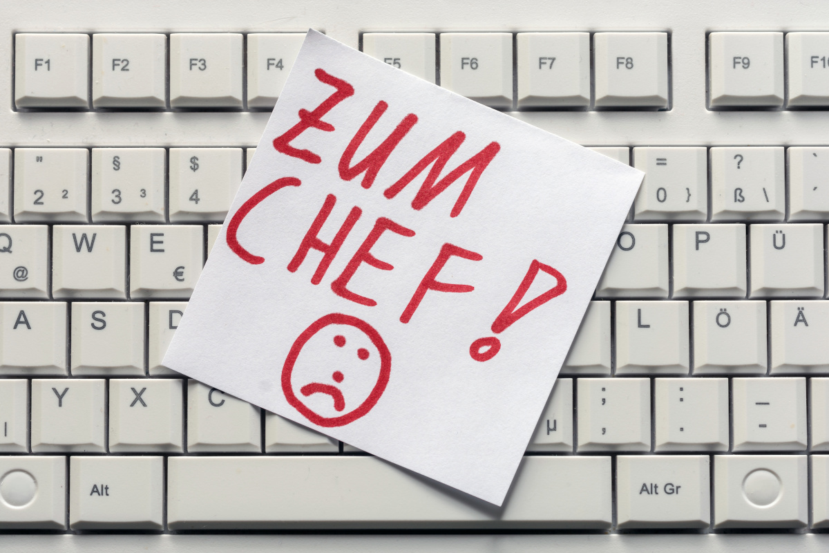 Abmahnung abwehren! Notizzettel "Zum Chef!" auf Tastatur, Symbolbild